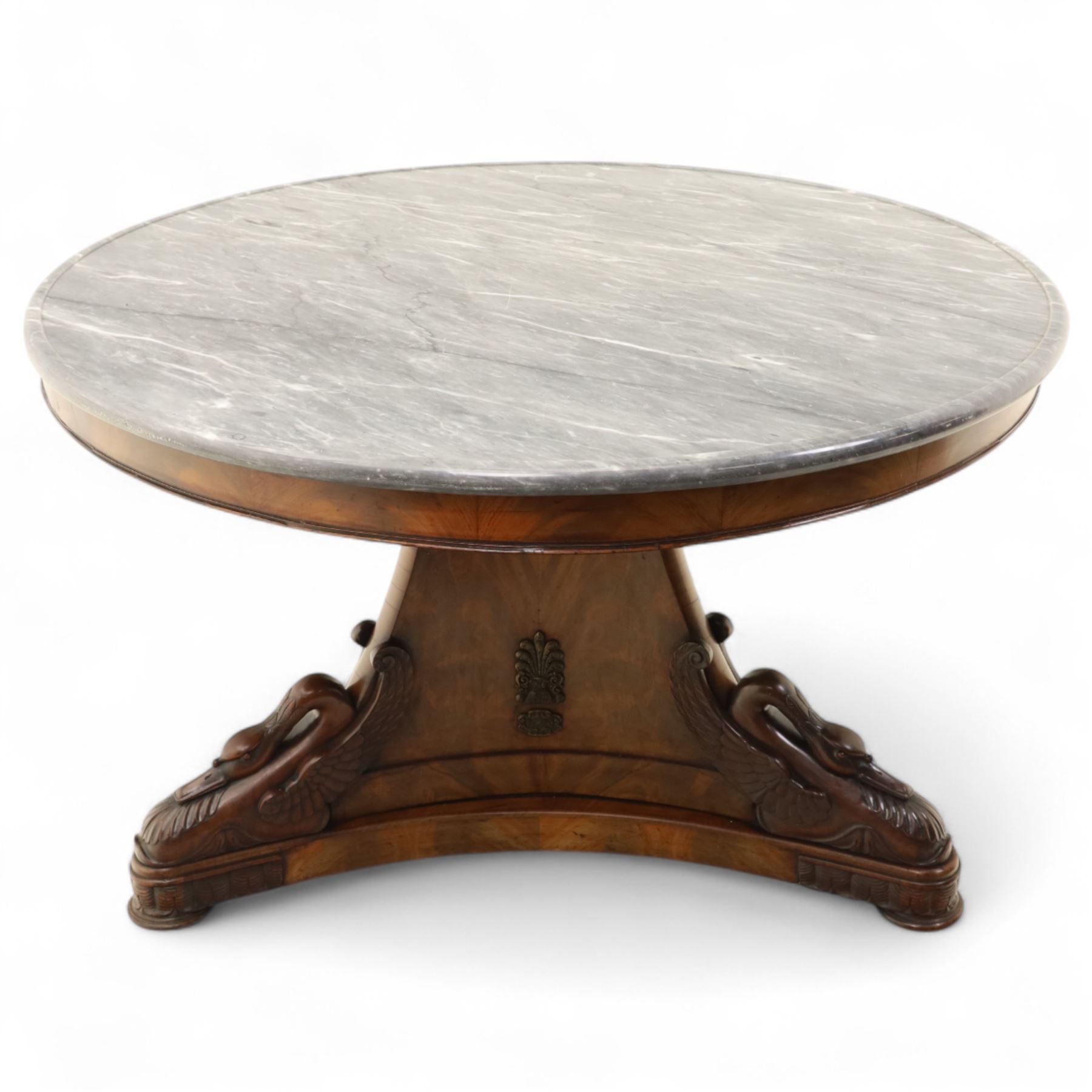 French mid-19th-century Second-Empire mahogany centre table with a dished grey-veined marble top, on a tapered triform pedestal with anthemion brass mounts above carved recumbent swan figures with delicately refined wings and graceful necks curving backwards, associated with the Empress Josephine, raised on three small platform bases