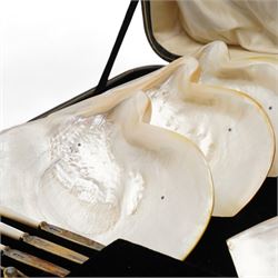 George V silver fruit service by William Hutton & Sons Ltd, comprising six mother of pearl plates, each mounted with three silver ball feet, together with six mother of pearl and silver fruit knives and forks, hallmarked Sheffield, 1911, 1917 and 1924, displayed in a silk and velvet fitted box, retailed by James R Ogdens & Sons, Harrogate, with original receipt label, shell W26cm, case W60cm 

Provenance: Nidd Hall: acquired by Guy Reed from Richard Butler, 17th Viscount Mountgarret, in 1968.