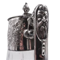 Modern silver mounted cut glass claret jug, in the Victorian style, the tapering cylindrical body with foliate embossed collar, Bacchus mask spout, conforming mask and foliate detail to angular scroll end handle, and hinged cover, hallmarked London 1994, makers mark W W, H27.5cm