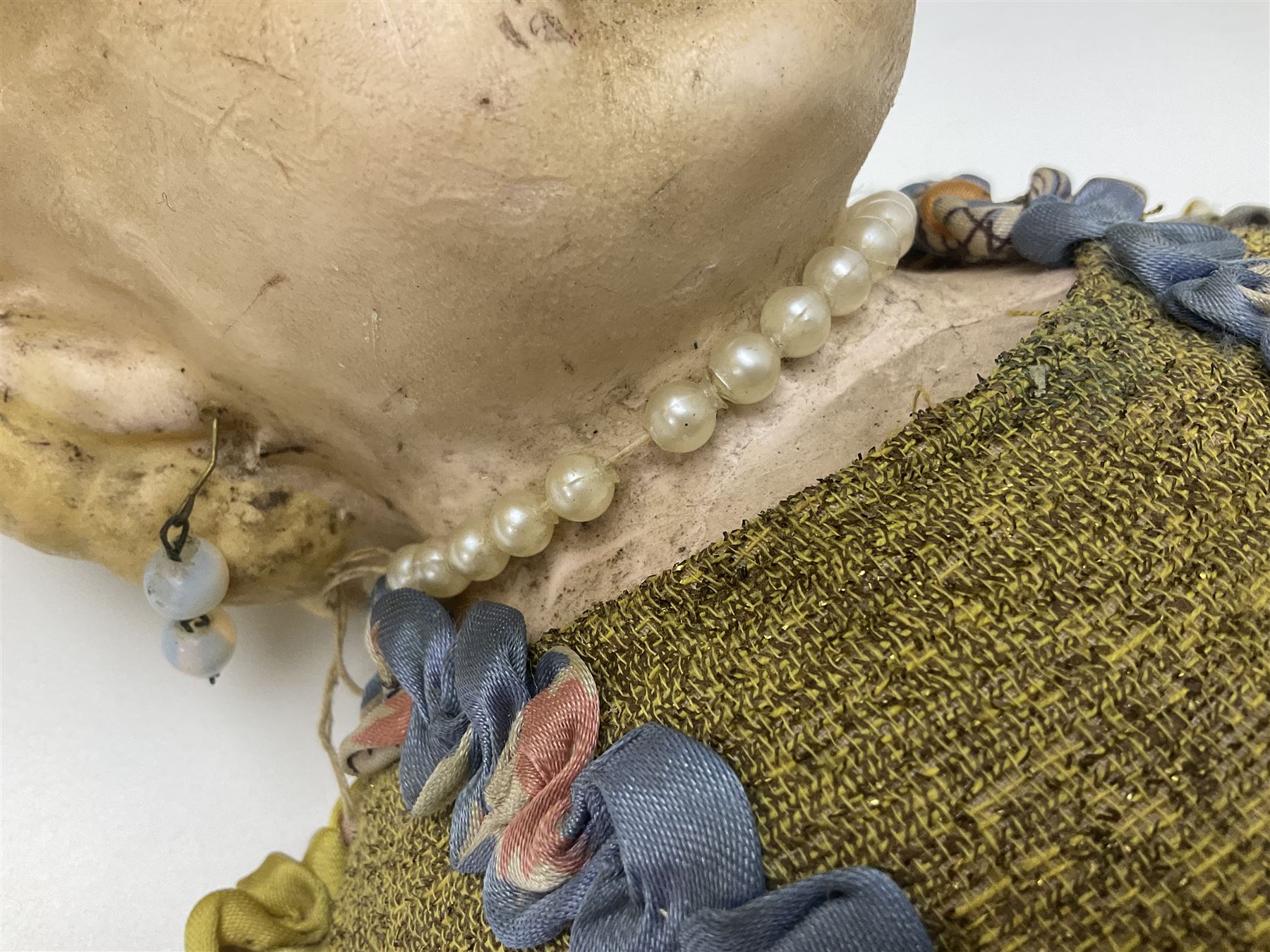 Victorian large wax over composition Pumpkin head doll, with inset dark glass eyes, moulded blonde hair in curls, stuffed body with carved and painted wooden limbs, grey painted boots, floral satin dress with netting underclothes H61cm