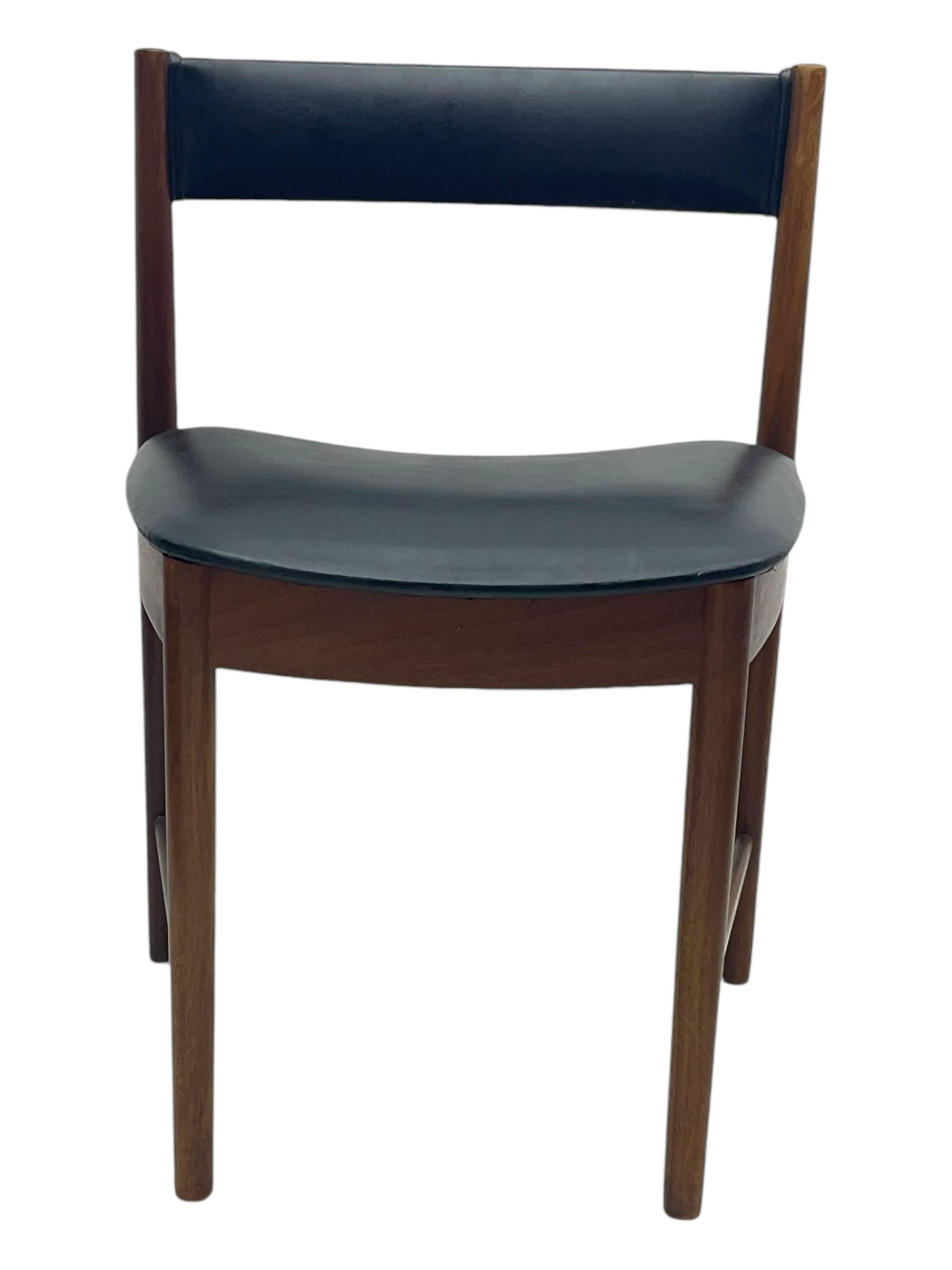 Mid-20th century teak extending dining table, circular top with pull-out extension and concealed leaf extension mechanism, on tapered supports; set of four teak dining chairs with black vinyl padded seats 