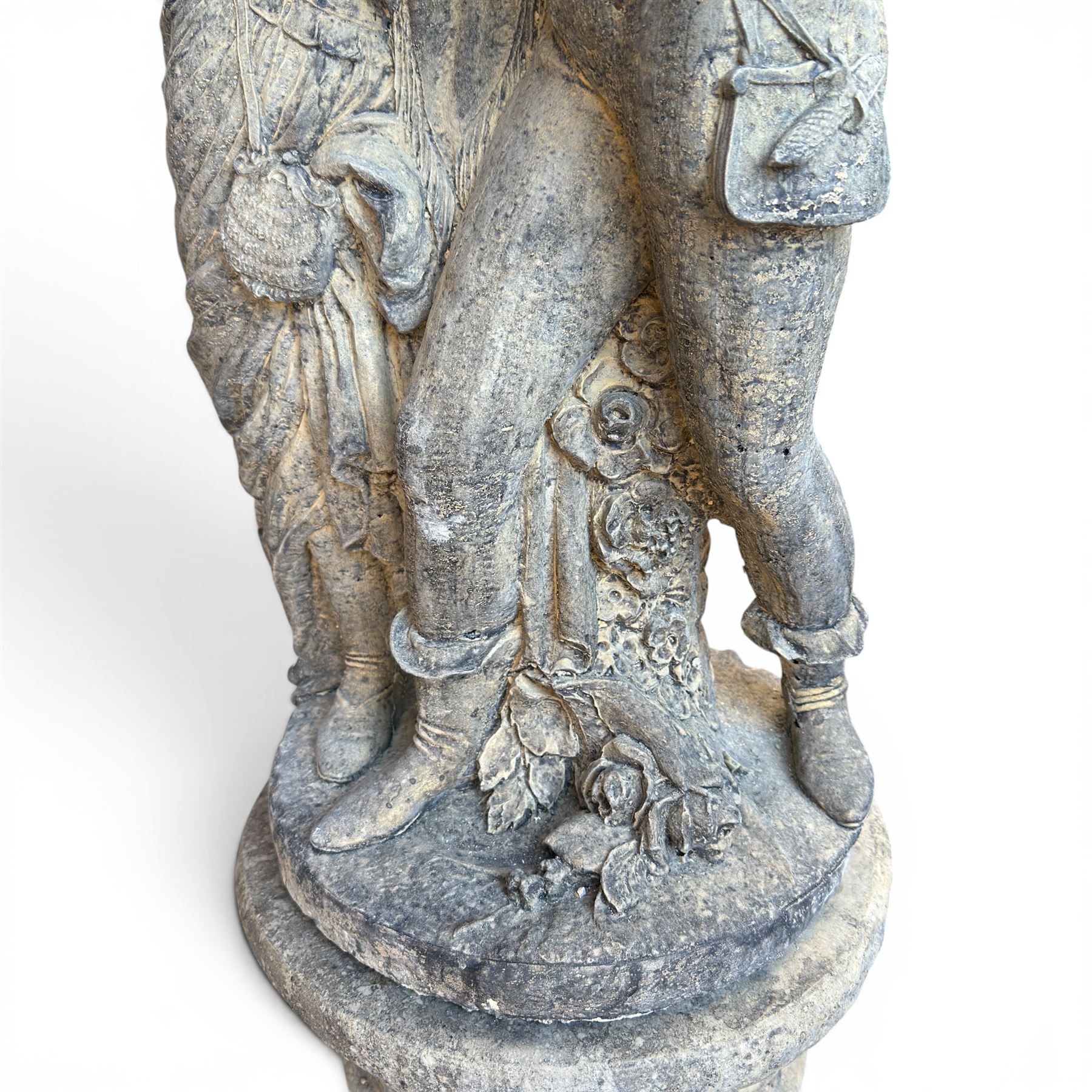 Composite garden statue group of Romeo and Juliet embracing, the couple adorned in Medieval dress standing on a naturalistic base with fallen flowers, raised on a Neoclassical fluted pedestal with Anthemion leaf motifs