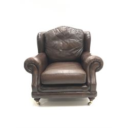 Thomas Lloyd wing back armchair upholstered in a brown leather, turned supports on castors