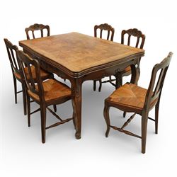 20th century French oak drawer-leaf extending dining table and six chairs, the rectangular parquetry top with moulded edge and rounded corners, pull-out draw leaves extending the table to 240cm, carved frieze with foliate detail, raised on cabriole supports with scroll terminals, the six matching chairs with shaped backs carved with floral motifs, paper cord seats woven with a green pattern, cabriole front supports and turned stretchers