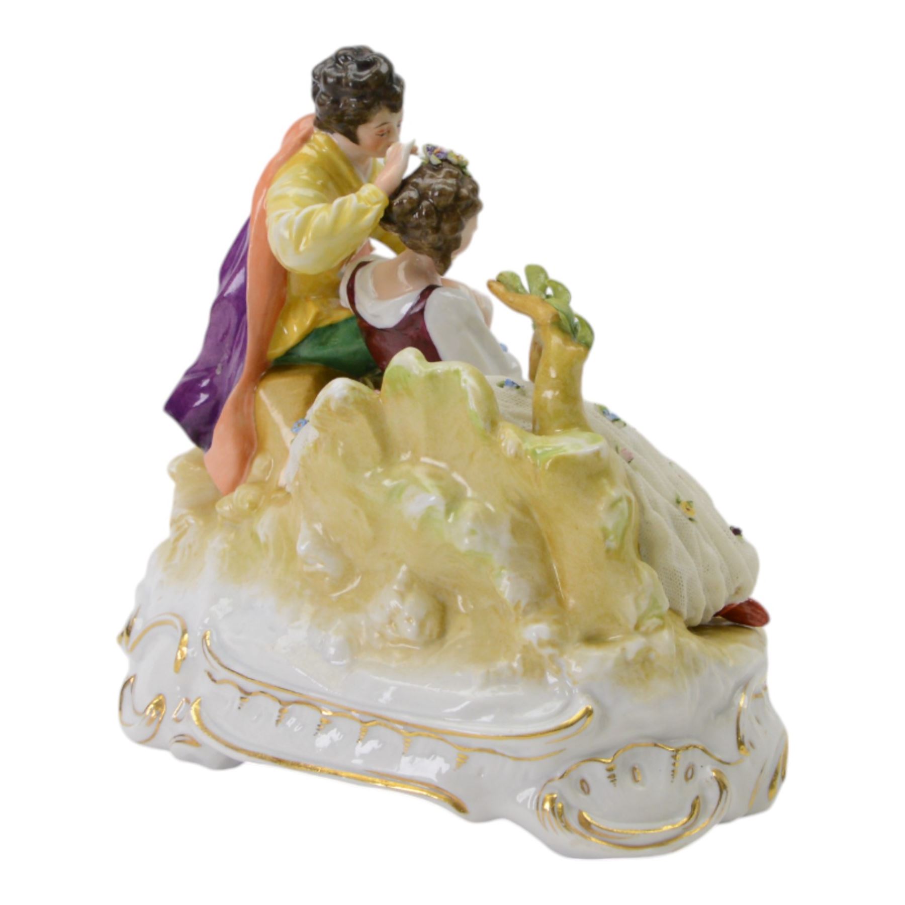 German lace figure group, modelled as a courting couple upon a naturalistically modelled base with gilt scroll edge, further detailed with two goats, encrusted flowers and tambourine, the female figure with lace flower encrusted skirt, with printed marks beneath, H21cm W26cm