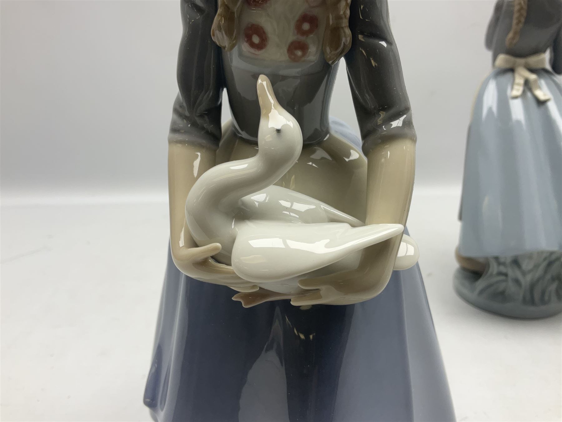 Three Lladro figures, comprising Dutch Girl with Braids no 5063, Dutch Girl with Duck no 5066 and Aracely with Ducks, all with original boxes, largest example H25cm