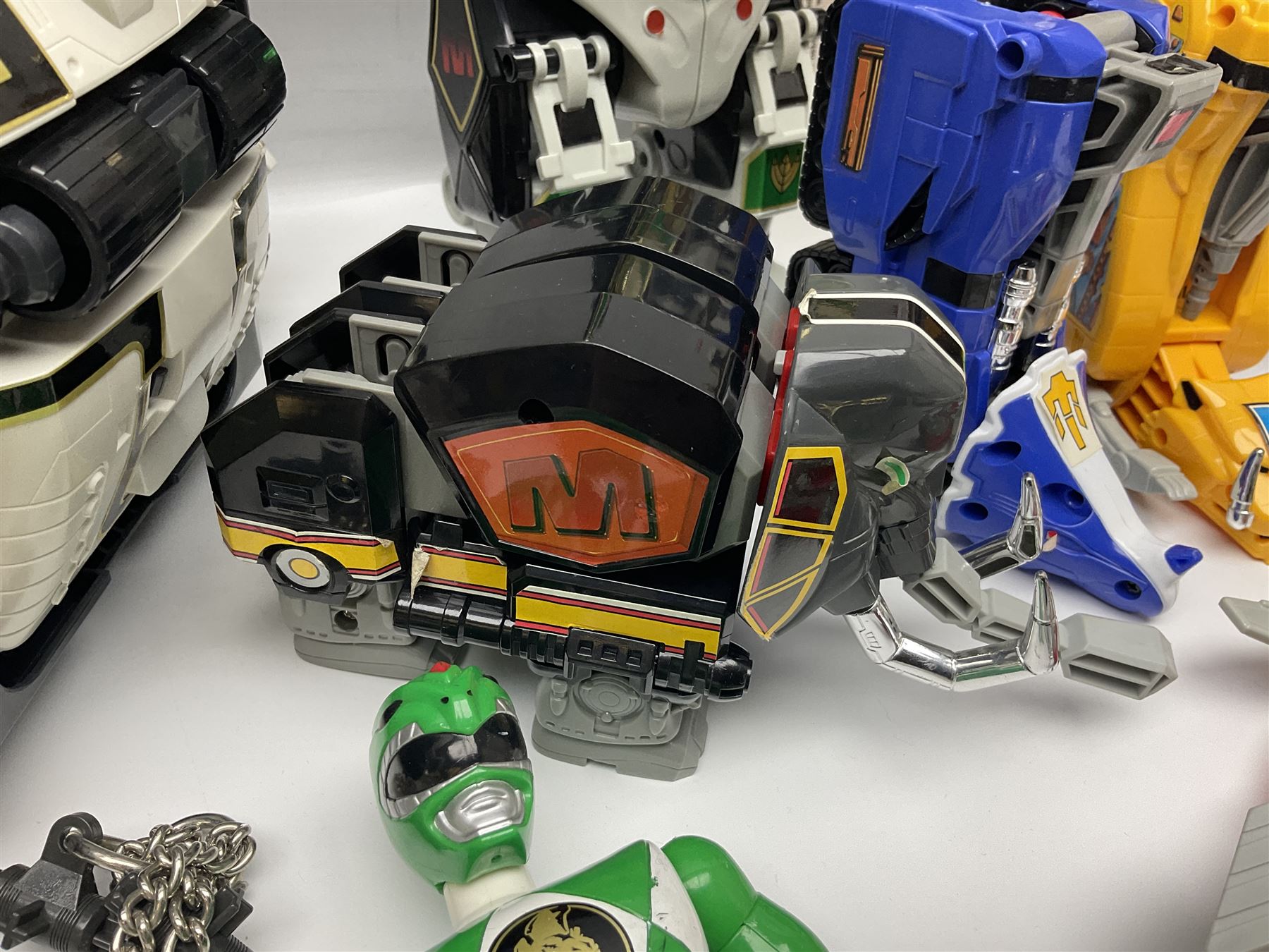 Collection of early 90s Mighty Morphin’ Power Rangers Zords, figures and accessories. Titanus the Carrier Zord, marked Bandai 1991; Green Dragonzord, incomplete; 1994 White Tigerzord with original instruction manual; 1993 Triceratops Dinozord, Mastodon Dinozord and Sabertooth Tiger Dinozord, Pterodactyl Dinozord, missing guns; with 1993 Power Morpher and original Power Coins, with further related figures, accessories and weapons