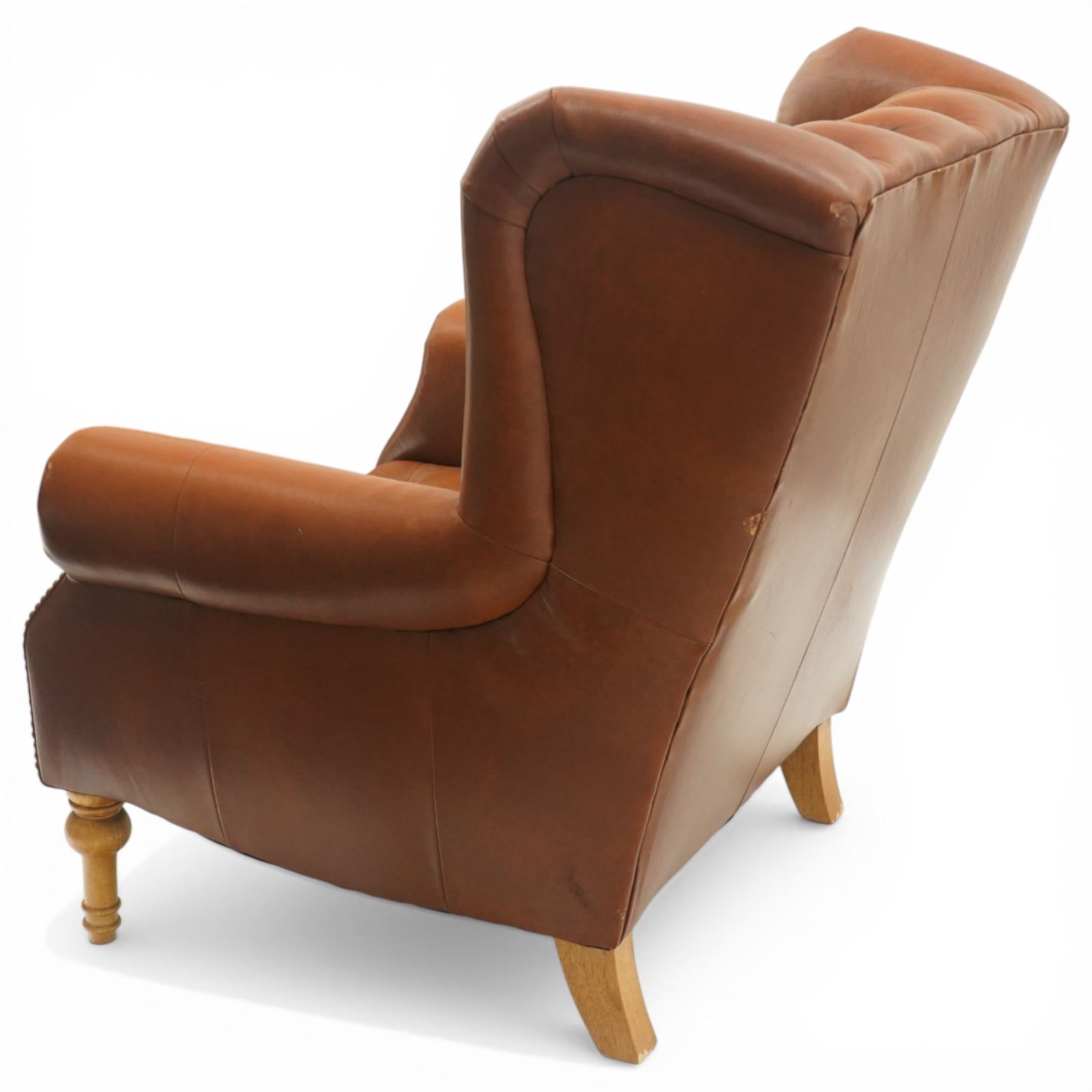 Alexander James design fully tan leather chair, with full button back seat and back, with scrolled arms with studded trim, raised on light stained turned supports