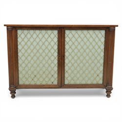 Late 20th century Regency style mahogany side cabinet, the rectangular crossbanded top with ebonised line inlay, above a pair of brass lattice grille doors with pale green fabric backing enclosing a shelved interior and two frieze drawers, flanked by reeded corner pilasters, upon turned tapering feet