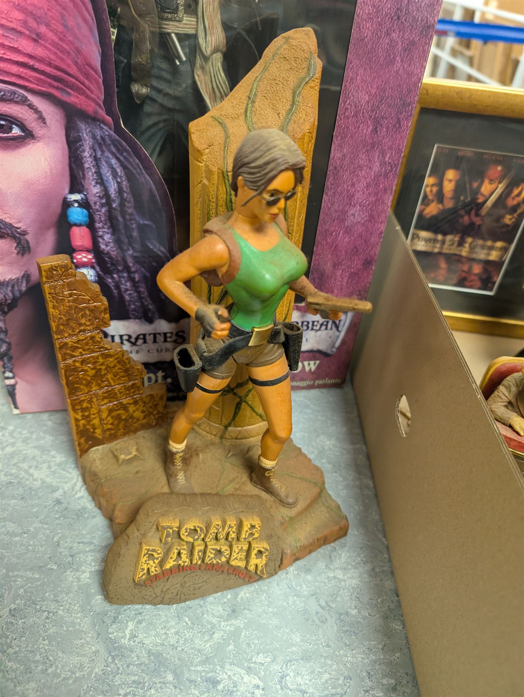 Collection of Disney and similar figures and memorabilia, including Pirates of the Caribbean Capt Jack Sparrow talking figure and NECA toys Jack Sparrow Head Knocker, three Disney showcase figures, Kermit the Frog framed film cell and Tomb Raider figure