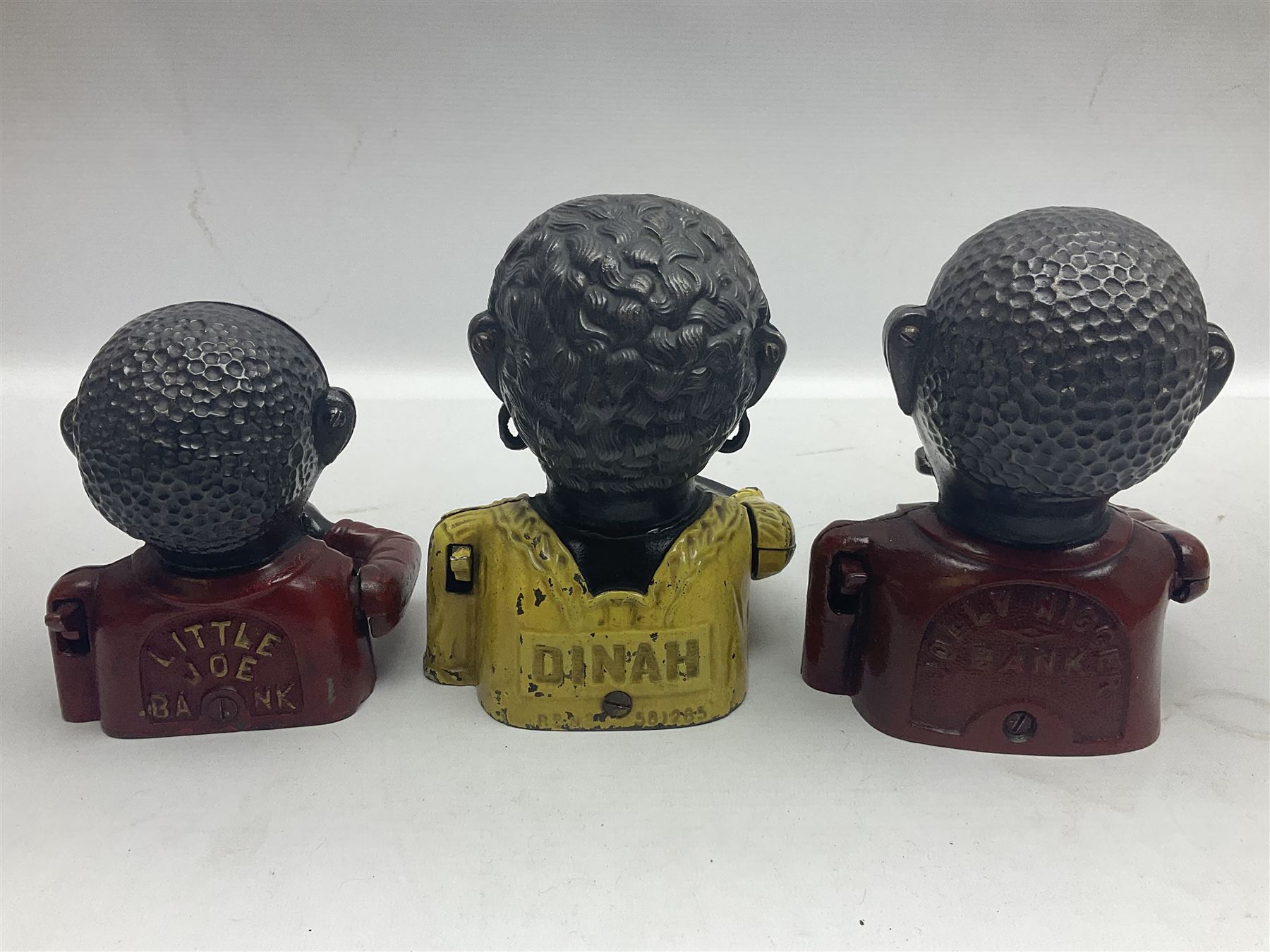 Three early 20th century cast-iron mechanical money banks as a family group comprising mother 'Dinah' patented 1911, father 'Jolly Man' patented 1902 and son 'Little Joe' patented 1910 by John Harper & Co; all with the same hand-to-mouth action; parents H16cm (3)