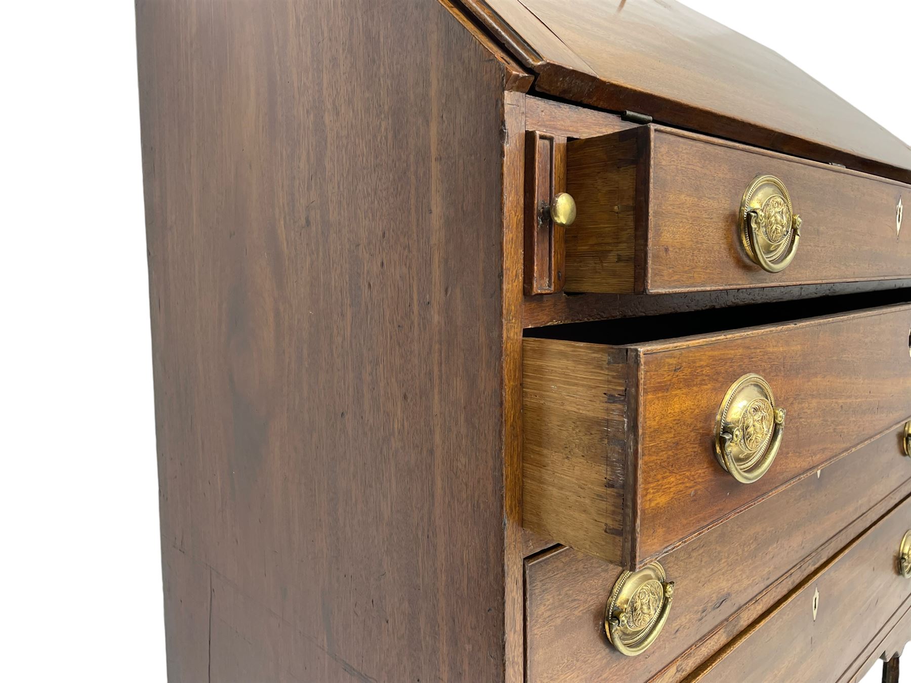 George III mahogany bureau, the fall-front banded and with boxwood stringing, enclosing fitted interior with pigeonholes and drawers surrounding a central cupboard with inlaid shell motif, the base with four graduating cock-beaded drawers, each with pressed brass handle plates with central lion masks and ivory escutcheons, on shaped bracket feet
This item has been registered for sale under Section 10 of the APHA Ivory Act