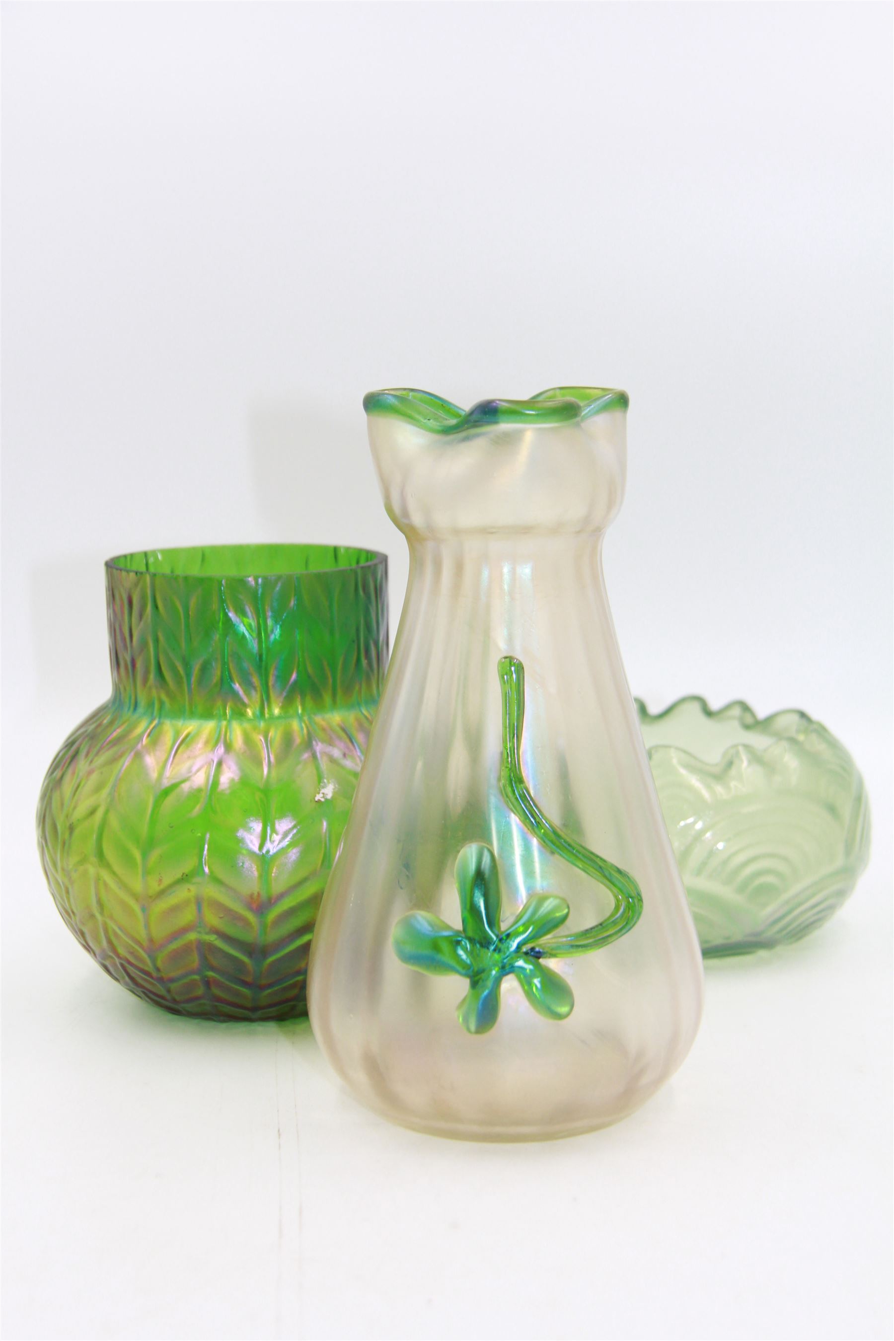 Three Austrian Art Nouveau iridescent glass vases, including a Kralik example of tapering form, with pearlescent lustre body and applied green flower decoration, tallest H18cm