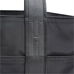 Hermès - Acapulco PM tote bag in black Toile Chevron canvas with black leather trim, the rectangular body with twin flat handles incorporating stitched H details, top zip fastening and eight exterior slip pockets, opening to a black nylon-lined interior with zip pocket, palladium-tone hardware, stamped Hermès Paris Made in France, with original Hermes dust bag