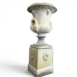 Cast stone classic garden urn, the rim decorated with leaves and berries, twin handles wit...