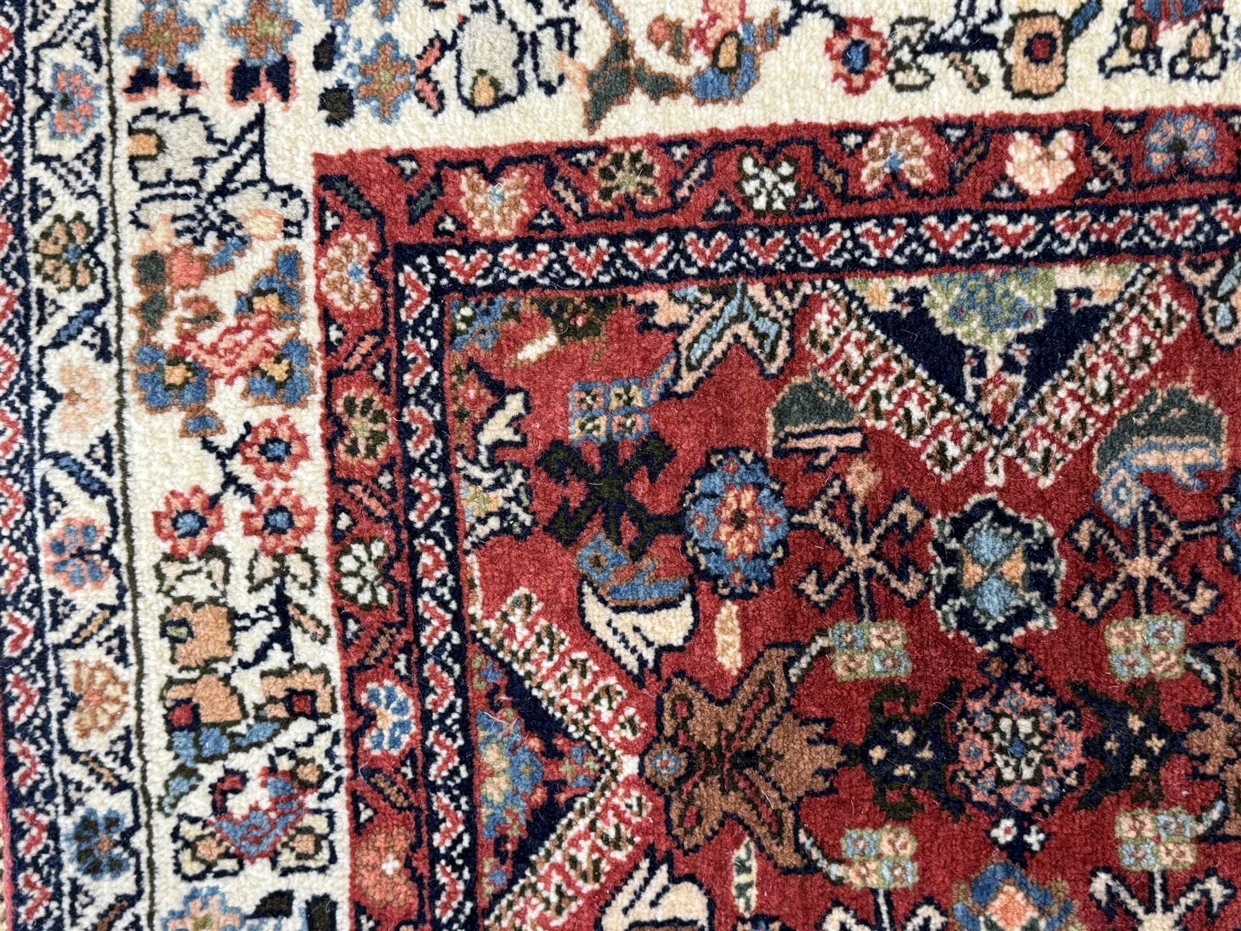 Pair of rugs one Persian hamadan rug central stepped medallion enclosing geometric motifs in ivory and brown, framed by a cream border with scrolling palmettes and fringed ends (H 156cm W 105cm), one Pakistani Bokhara rug rust red ground with repeated Tekke gul motifs within rosette and lozenged borders, fringed ends (H 98cm, W 65cm)