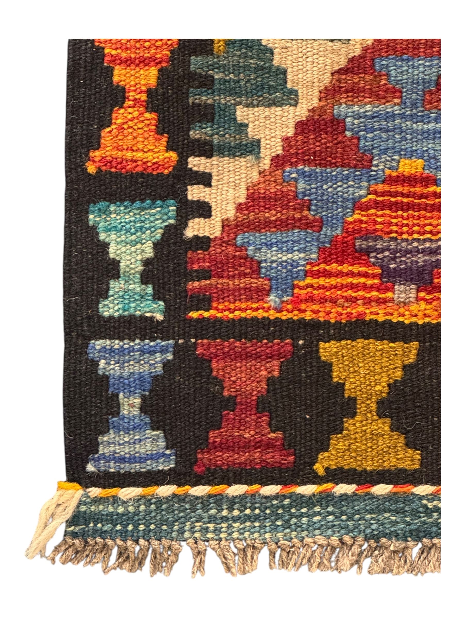 Afghan Maimana flatweave Kilim rug, the field decorated with multi-coloured diamond motifs in a stepped formation, framed by a bold hourglass border,