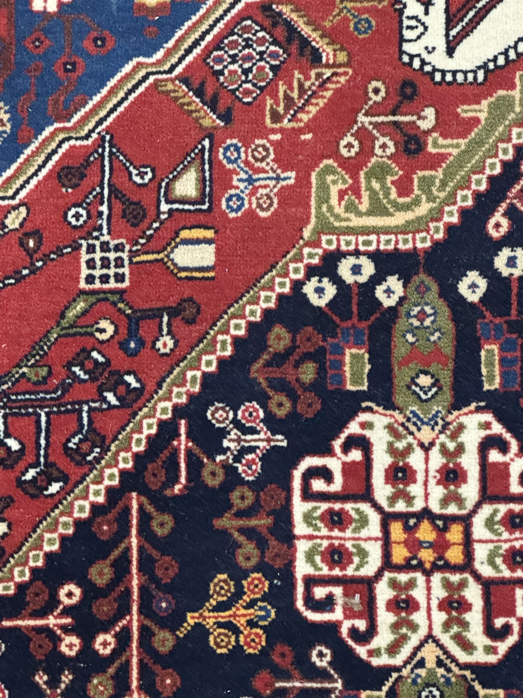 Fine Persian Qashqai crimson and navy ground runner, three large medallions filled with geometric and floral designs, the field with angular vines and stylised floral decoration, wide ivory border decorated with repeating floral and angular motifs