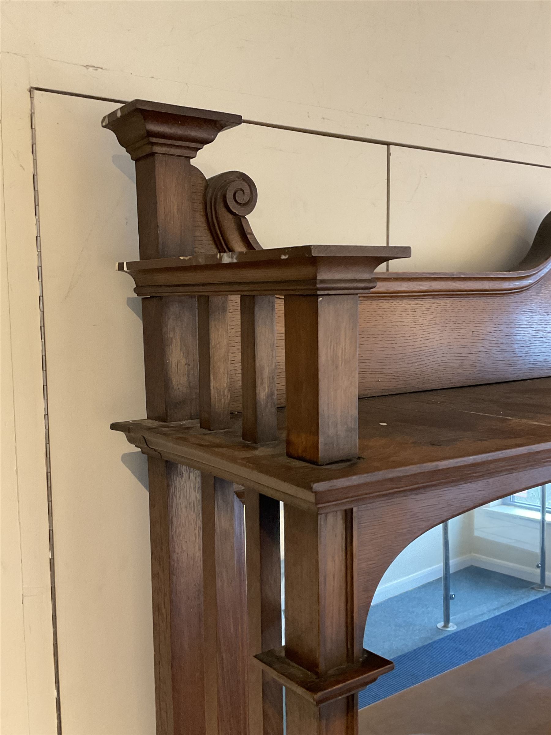Late 19th century Arts & Crafts period oak mirror back sideboard, shaped bevelled mirror back carved with foliate scrolls and flower heads, down swept supports with elongated club-shaped uprights, moulded rectangular top over two drawers and three cupboards, the drawer fronts with copper handles decorated with sailing ships, panelled doors carved with mythical beasts, flowerheads and foliage, on moulded block feet