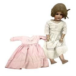 Heubach Koppelsdorf bisque socket head doll, with light brown hair, blue glass sleeping eyes, and open mouth with applied teeth, the jointed composition body donning a white dress together with a further pink dress, L60cm