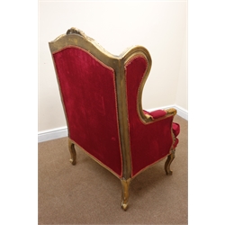  French upholstered wing back chair, the gilt frame with scroll carved cresting and acanthus arms, serpentine frieze on cabriole legs, loose seat cushion, W76cm, D68cm, H123cm   