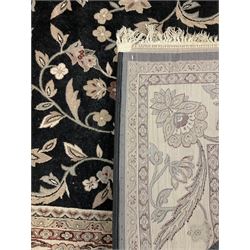 Persian design dark indigo ground rug, the field decorated with trailing branches and foliate motifs, repeating scrolling border with stylised plant motifs