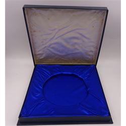 Modern limited edition silver salver, celebrating the achievements of Grundy, champion racehorse of 1975, each of circular form with gadrooned rim and plaque to centre depicting jockey mounted upon Grundy, designed by Stuart Devlin, limited edition no. 15/500, hallmarked London 1976, makers mark LH, D23cm, within silver lined fitted box and limited edition certificate 