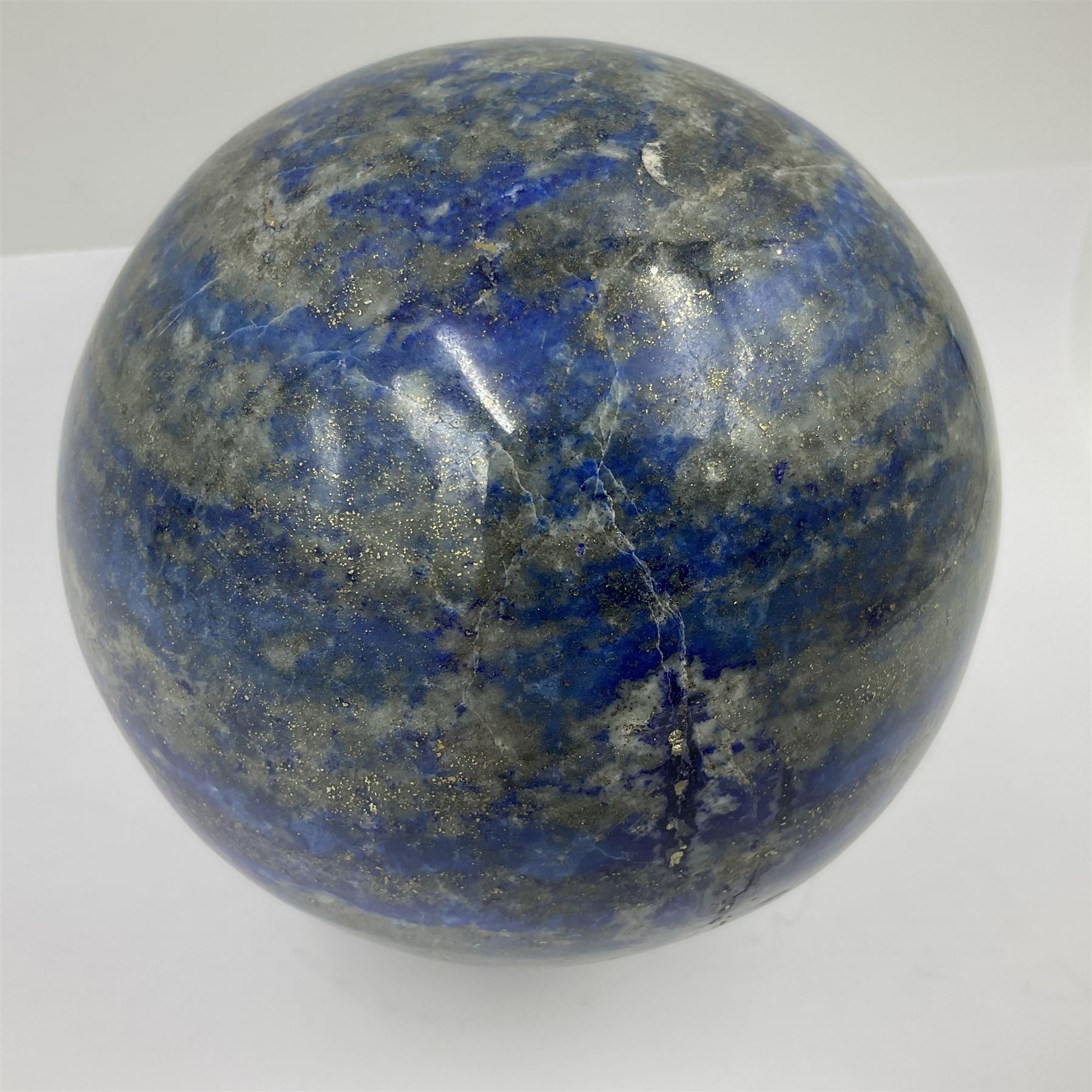 Lapis lazuli sphere upon a carved wooden base 