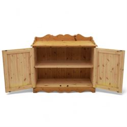 Contemporary pine cupboard, with raised shaped gallery over plain top, panelled double doors below with turned knob handles, shaped apron and plinth base