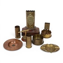 Collection of trench art, including a vase with scalloped rim, applied with a helmet plate...