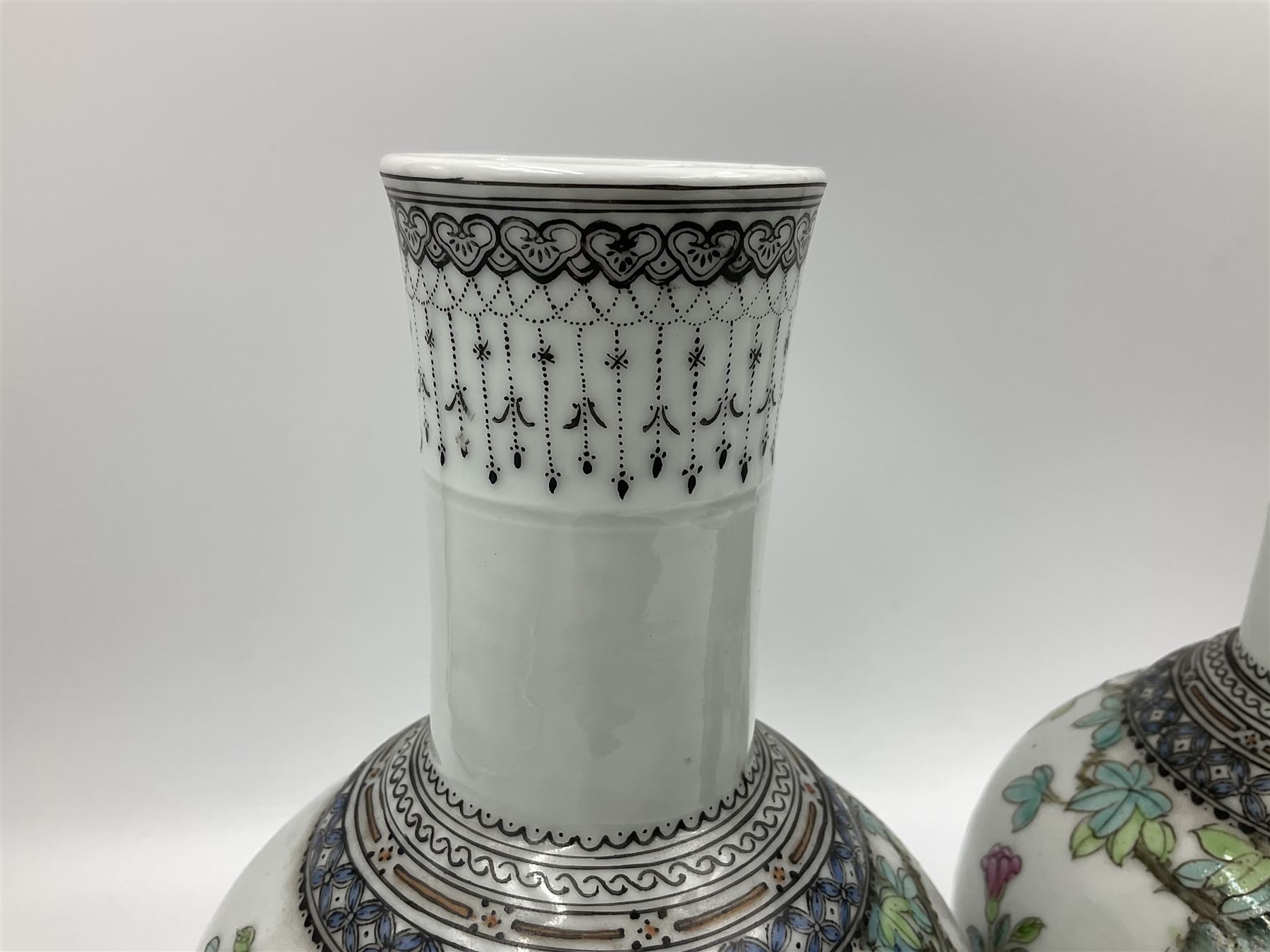 Pair of Chinese Republic porcelain vases, each painted in Famille Rose enamels with pairs of pigeons amidst peony, rock, flowering plants and leafy branches, possibly Qianlong seal beneath, H22cm 