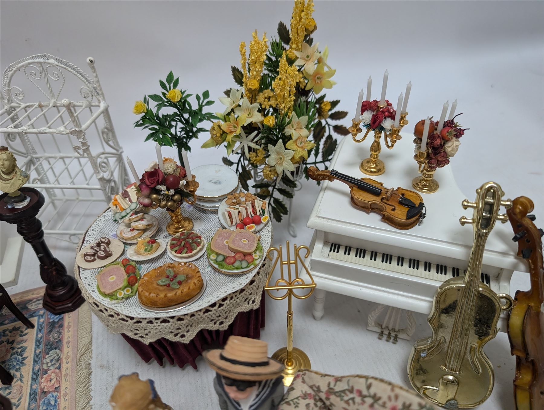 Dolls house furniture, including pianos, fireplace, plants, flower arrangements, tables, chairs, six figures and a collection of instruments and other accessories