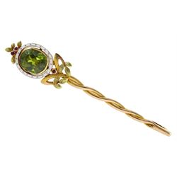 Early 20th century 14ct gold German peridot brooch, oval peridot of approx 9mm x 8mm, depth approx 4.5mm, with white enamel surround and three small rubies and a twist stem, retailed by Koch Frankfurt a/m Baden Baden in a silk lined fitted box