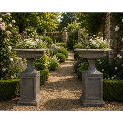 Pair of cast stone garden urns of kylix form on pedestals, the broad egg-and-dart moulded ...