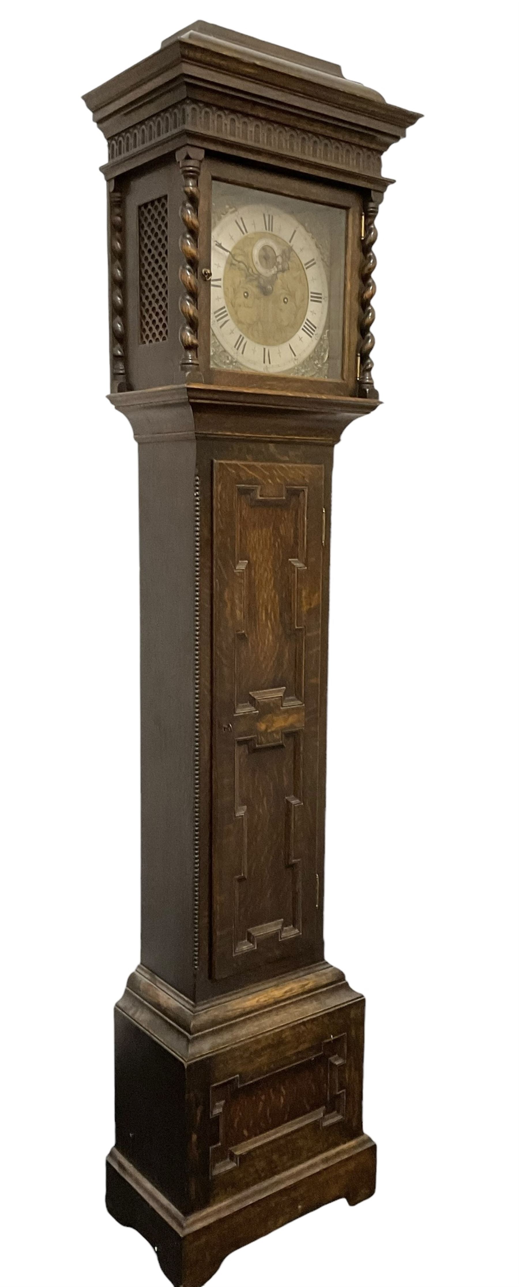 8-day oak longcase clock - in an early 18th century styled case with a caddy top, square hood door with barley twist columns, long carved trunk door on a conforming plinth with an applied skirting base, square brass dial with an engraved centre, silvered chapter and spandrels, 19th century rack striking movement, striking the hours on a bell. With weights and pendulum.