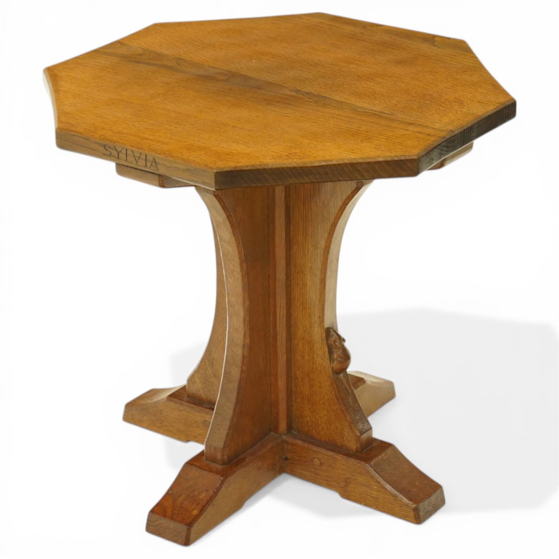 Mouseman - 1950s oak coffee table, octagonal adzed top on cruciform base and sledge feet, carved with mouse signature, dated 1956 and engraved 'Sylvia' to the top edge, by Ken Almack of the workshop of Robert Thompson, Kilburn

Notes:
Made by Ken Almack at the Robert Thompson workshop, Kilburn, where he trained and worked as a Mouseman craftsman; brother of Colin ‘Beaverman’ Almack, who later established his own workshop. The table was made for Sylvia to mark their engagement in 1956, prior to their marriage in 1957.

Provenance: The estate of Ken Almack; Tennants Auctioneers, 20th Century Design, 5 October 2024.