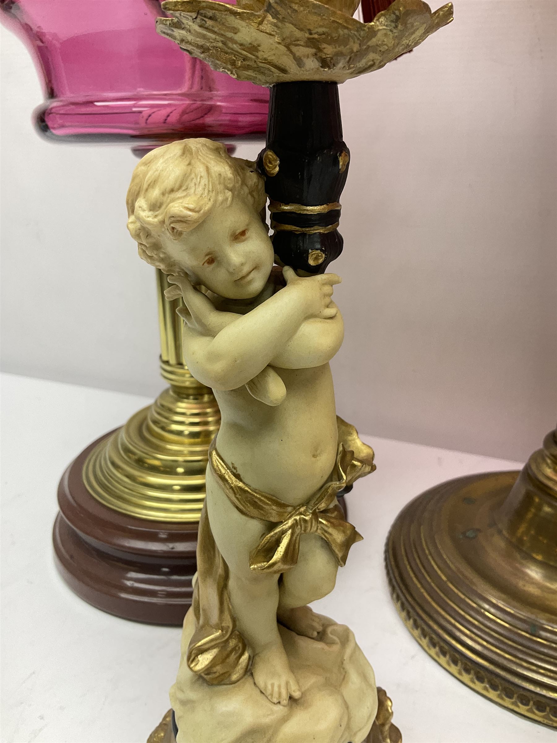 Victorian cast brass oil lamp, with fluted pink glass shade, together with two smaller brass oil lamps with pink shades and reservoirs and a pair of oil lamps, the bases modelled as putti, with pink glass reservoir  and frosted shades, tallest H70cm