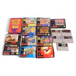 Two Super Nintendo Entertainment System consoles, accessories to include Super Multitap, UFO Super Drive Pro, Universal Adapter, Game Genie, Scope 6 accessories (Scope not present), seven controllers including one Competition Pro and a SN Pro Pad and fifteen SNES games comprising eleven boxed and four unboxed examples, titles to include Dragon The Bruce Lee Story, Street Fighter II Turbo x2 (one unboxed), Royal Rumble, Super Mario Kart, Radical Psycho Machine Racing, Super Bomberman, Super Bomberman 2, Protector Alien Rebels, Double Dragon, Goof Troop, WWE Raw Wrestling, Tetris Attack, Donkey Kong Country and Starwing