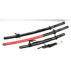 Reproduction Japanese sword daisho of katana and wakisashi with matching tanto; together with another reproduction katana; all with simulated fish skin grip and lacquered saya (4)