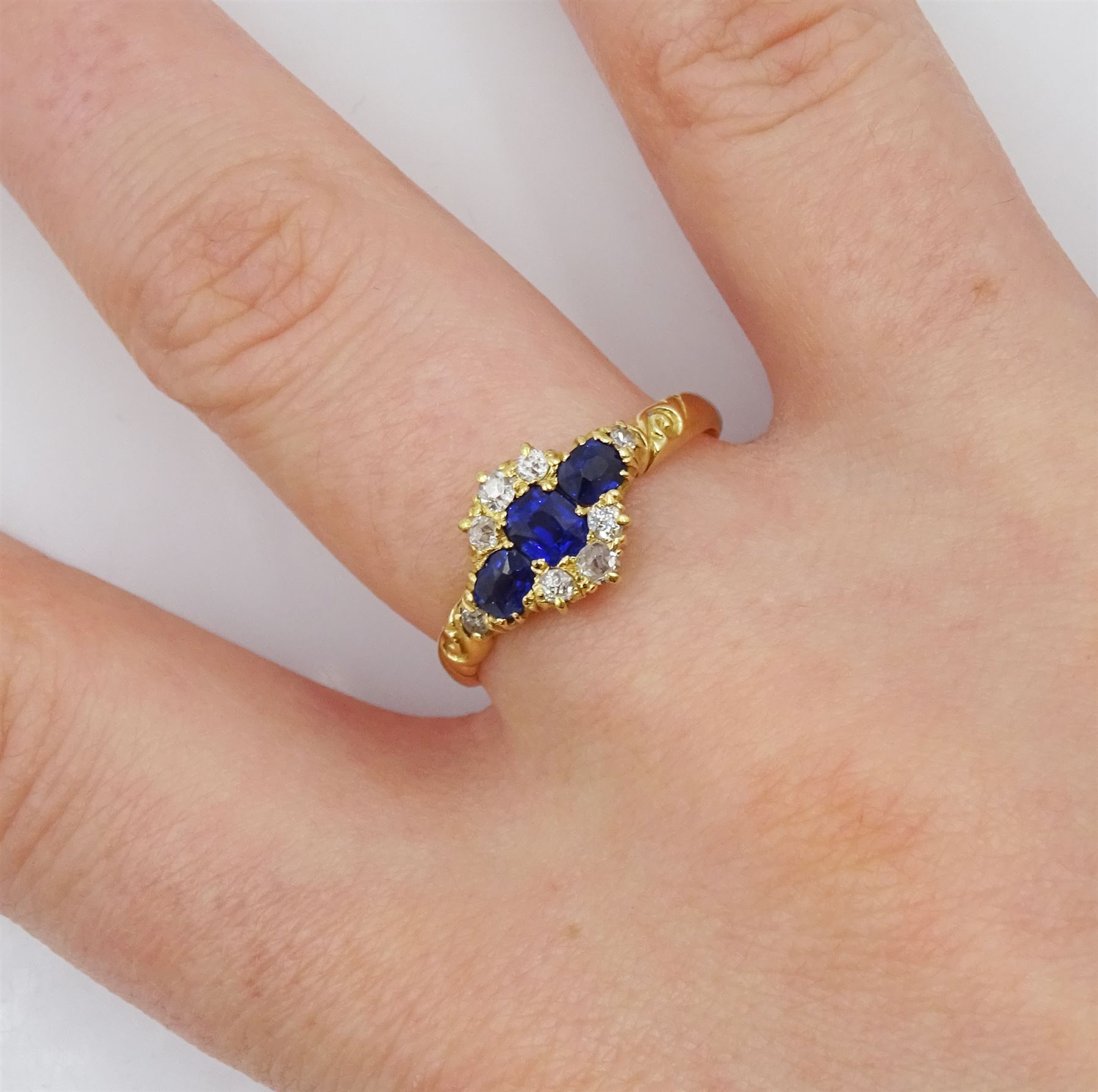 Victorian 18ct gold sapphire and diamond cluster ring, with engraved scroll design shoulders, Birmingham 1896