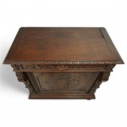19th-century heavily carved oak baroque style cupboard with vine and floral carved frieze drawer above panelled cupboard door with floral carved appliqué (detached) flanked by symmetrically carved scroll and vine decorated sides, on bun feet 