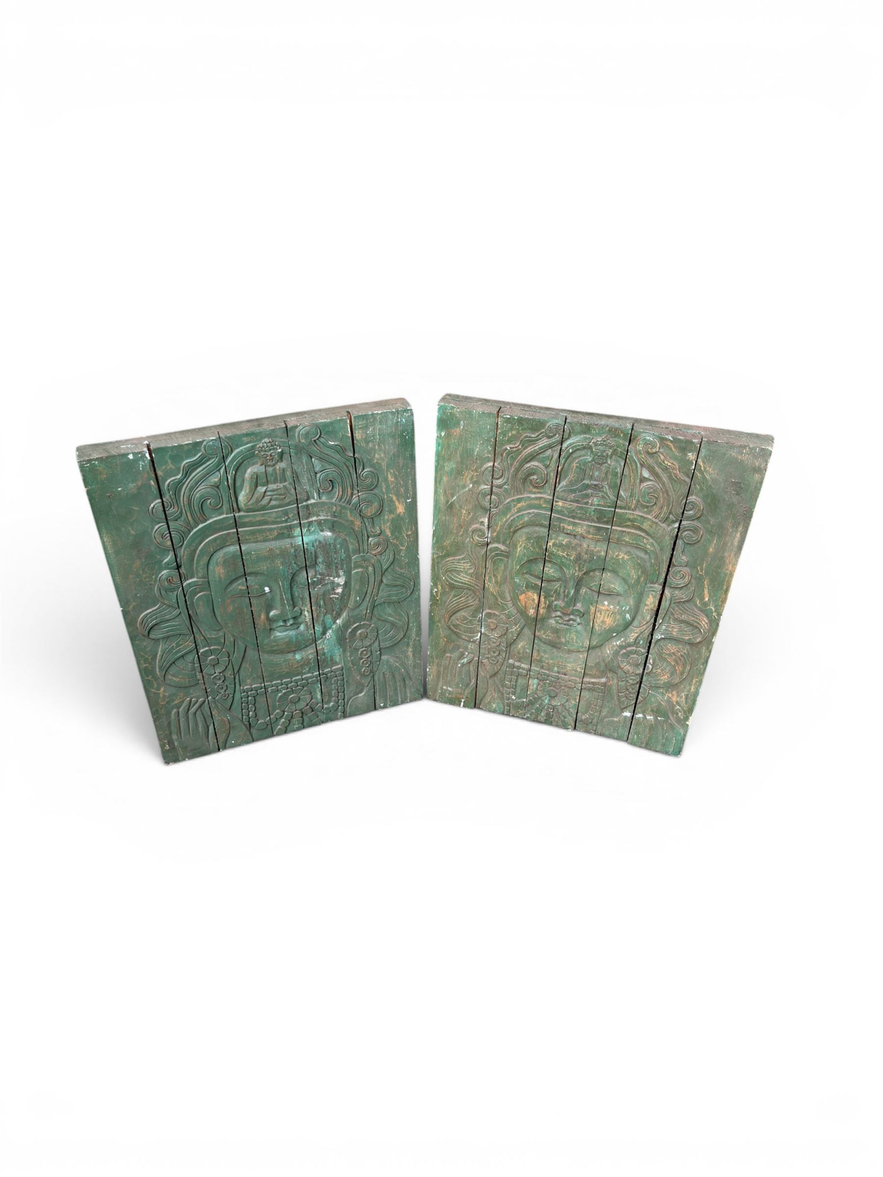 Pair of South East Asian carved wooden panels, depicting Buddha or Deity faces