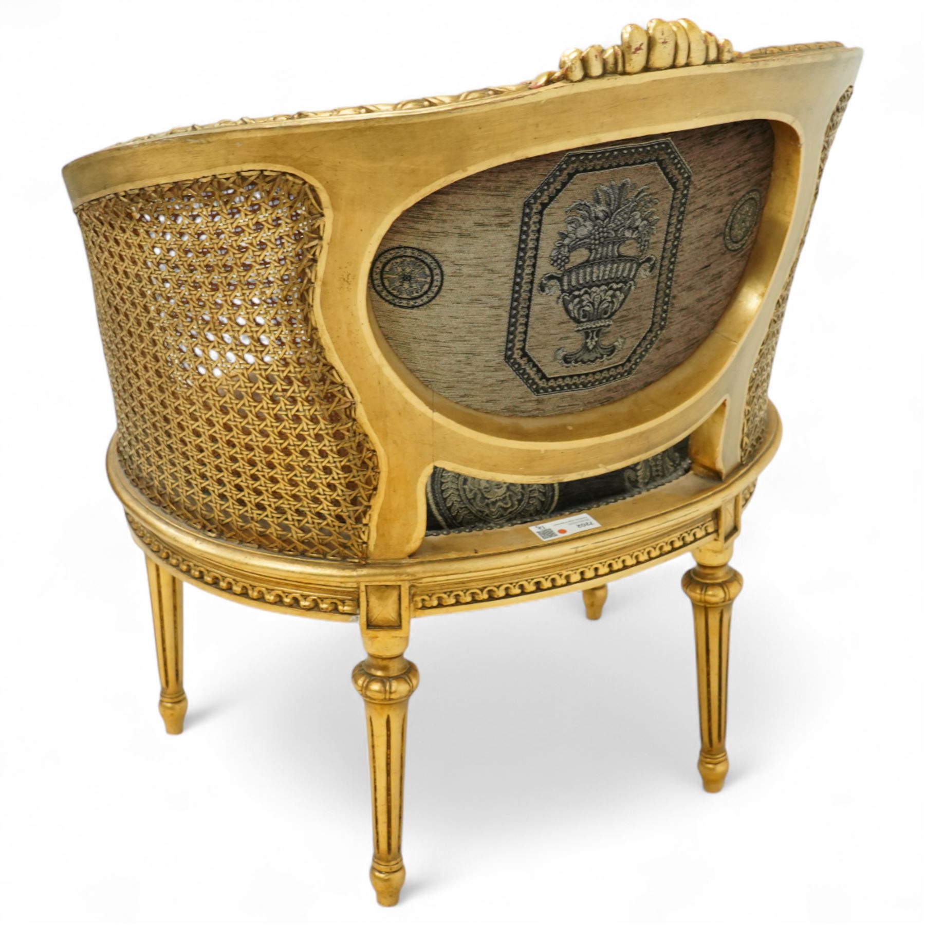 Louis XVI design tub armchair, studded upholstered padded back and seat with double cane side panels on fluted legs 