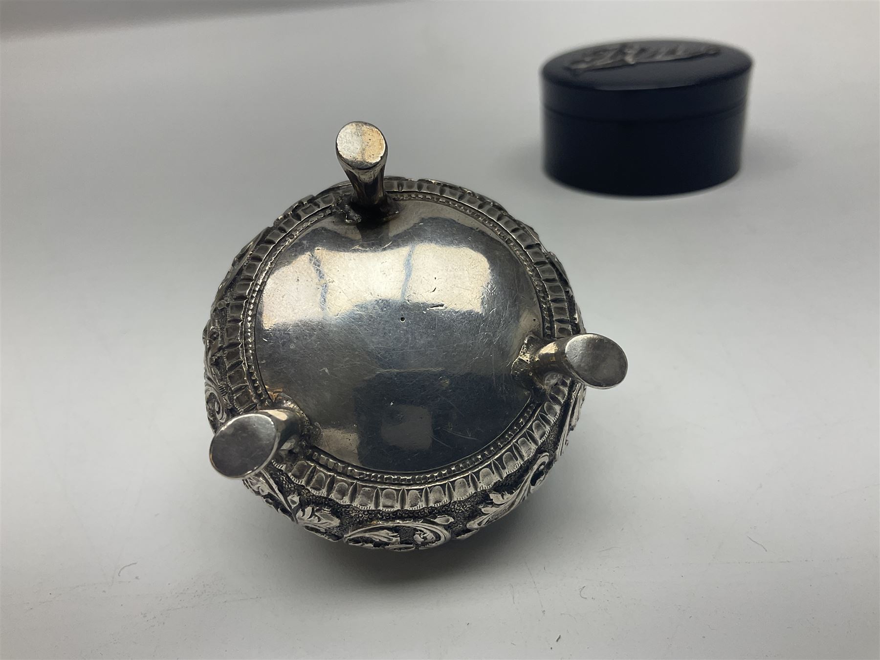 Three pin cushions, comprising gilt metal pig, silver plate shoe, circular pin cushion on threel feet, together with black pin holder with silver writing to the lid 