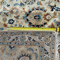 Central Persian Kashan rug, cream ground densely decorated with interconnected floral stems, rosettes and palmettes in shades of blue and gold, framed by layered foliate borders, woven in the Kashan region of Iran