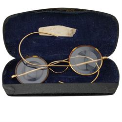 Painted enamel depiction of Jesus, in brass surround, together with a pair of gold plated faux tortoiseshell rimmed spectacles, in glasses case