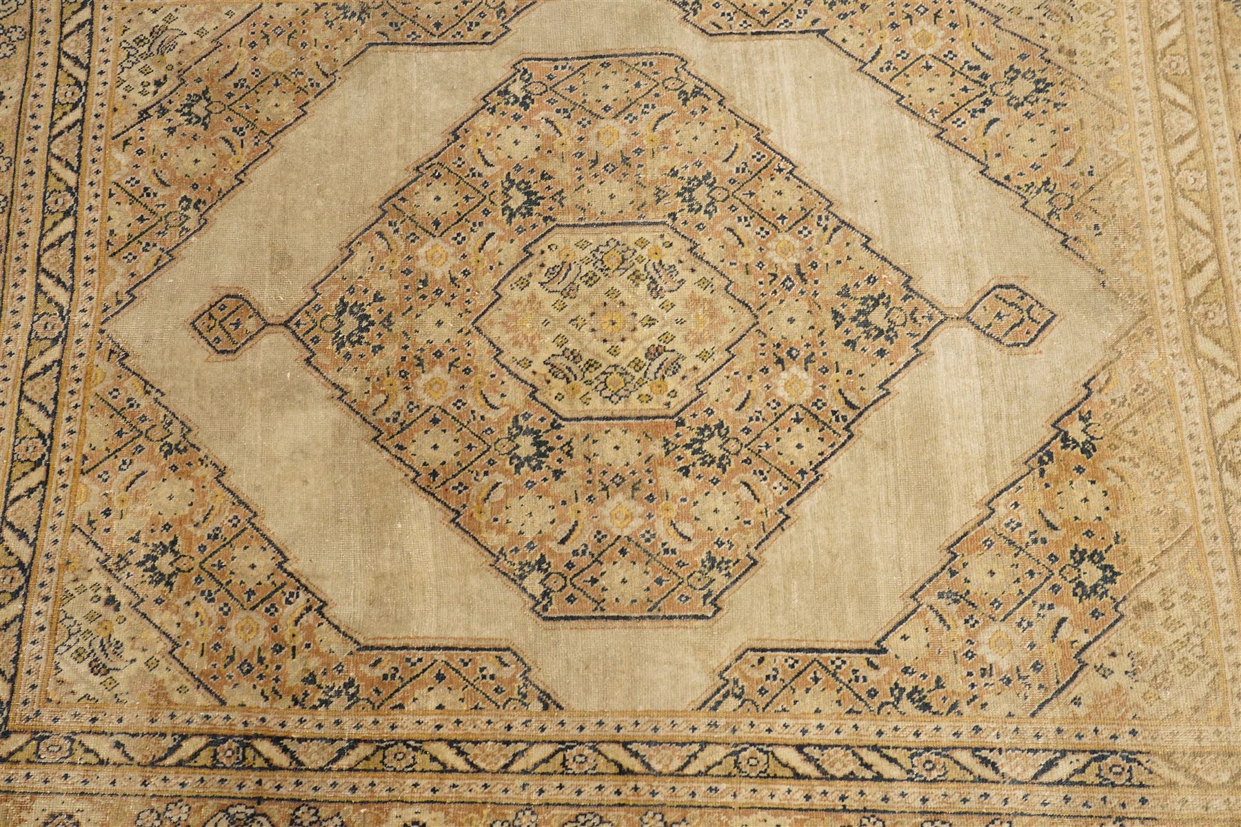 Two hand-knotted rugs, comprising Persian medallion rug and tribal rug, Persian hand-knotted rug, ivory ground centred by shaped floral medallion with pendants, surrounded by stylised flowerheads and foliate motifs, enclosed by multiple floral and geometric borders, H155cm, W123cm; tribal hand-knotted rug, dark brown ground with repeating linked geometric diamond medallions in orange and green, enclosed by ivory geometric border, striped ends with fringes, H150cm, W71cm