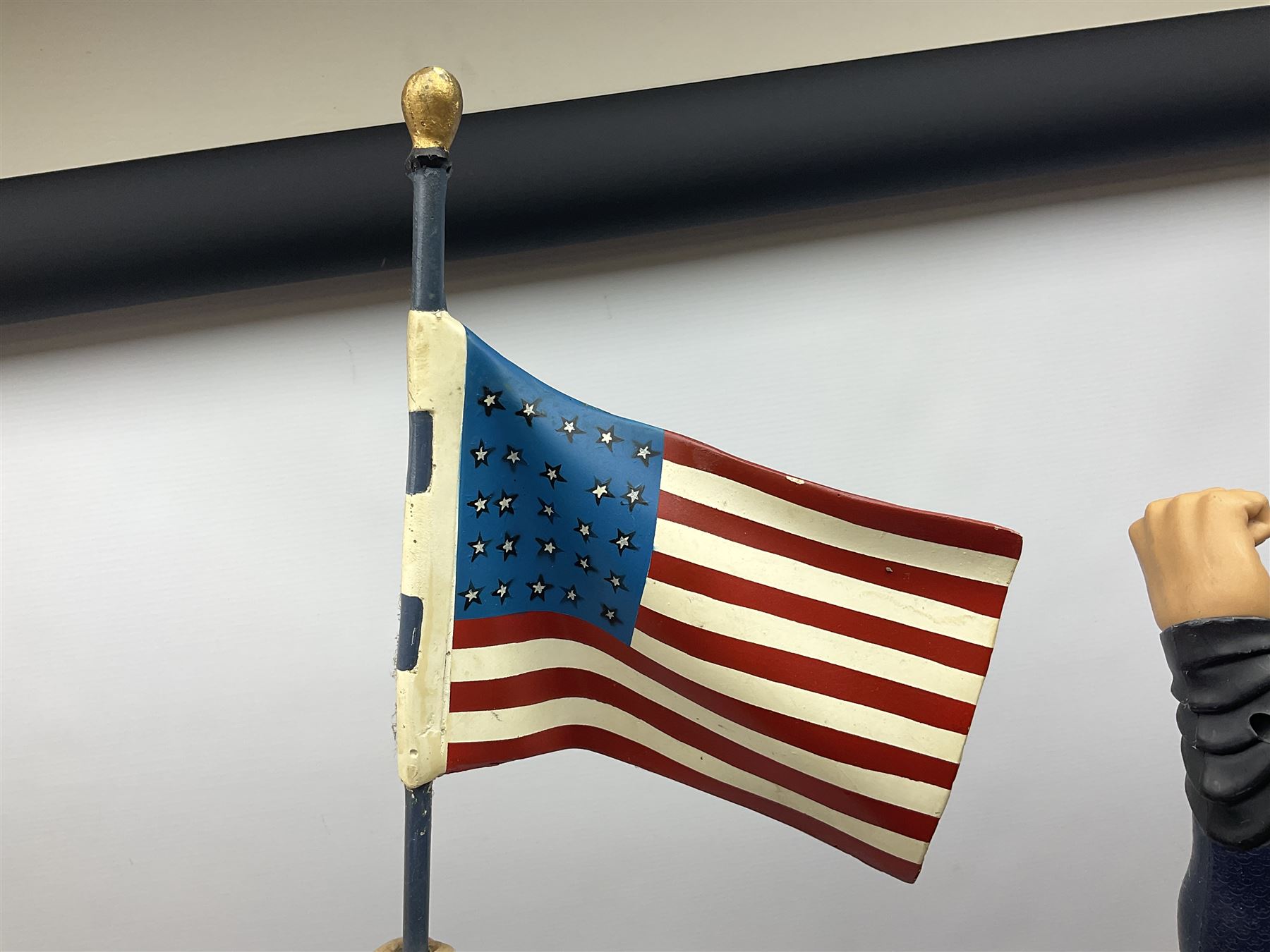 Composite Superman with cape, together with a composite female statue holding the American flag, tallest example H103cm