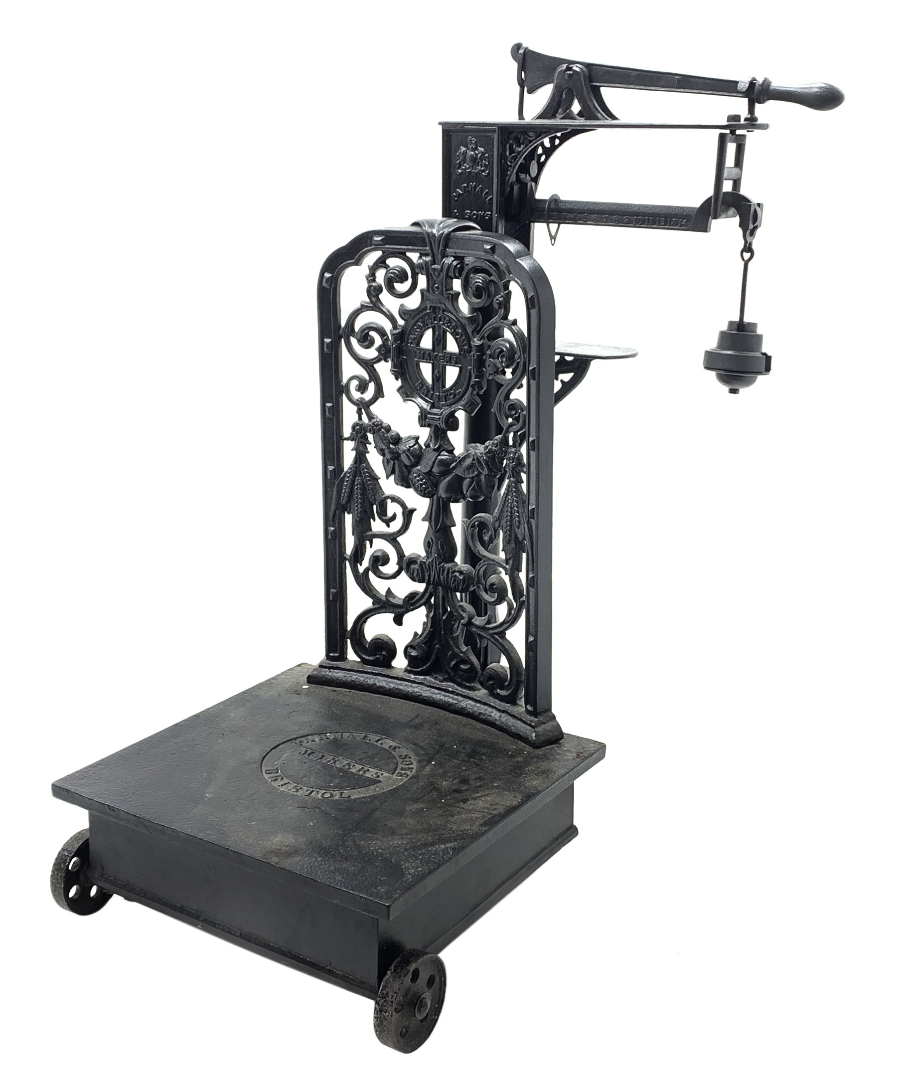 19th century platform scales by Parnall & Sons. Bristol, black painted cast iron, raised back decorated with foliage scrolls and fruit garland, H128cm