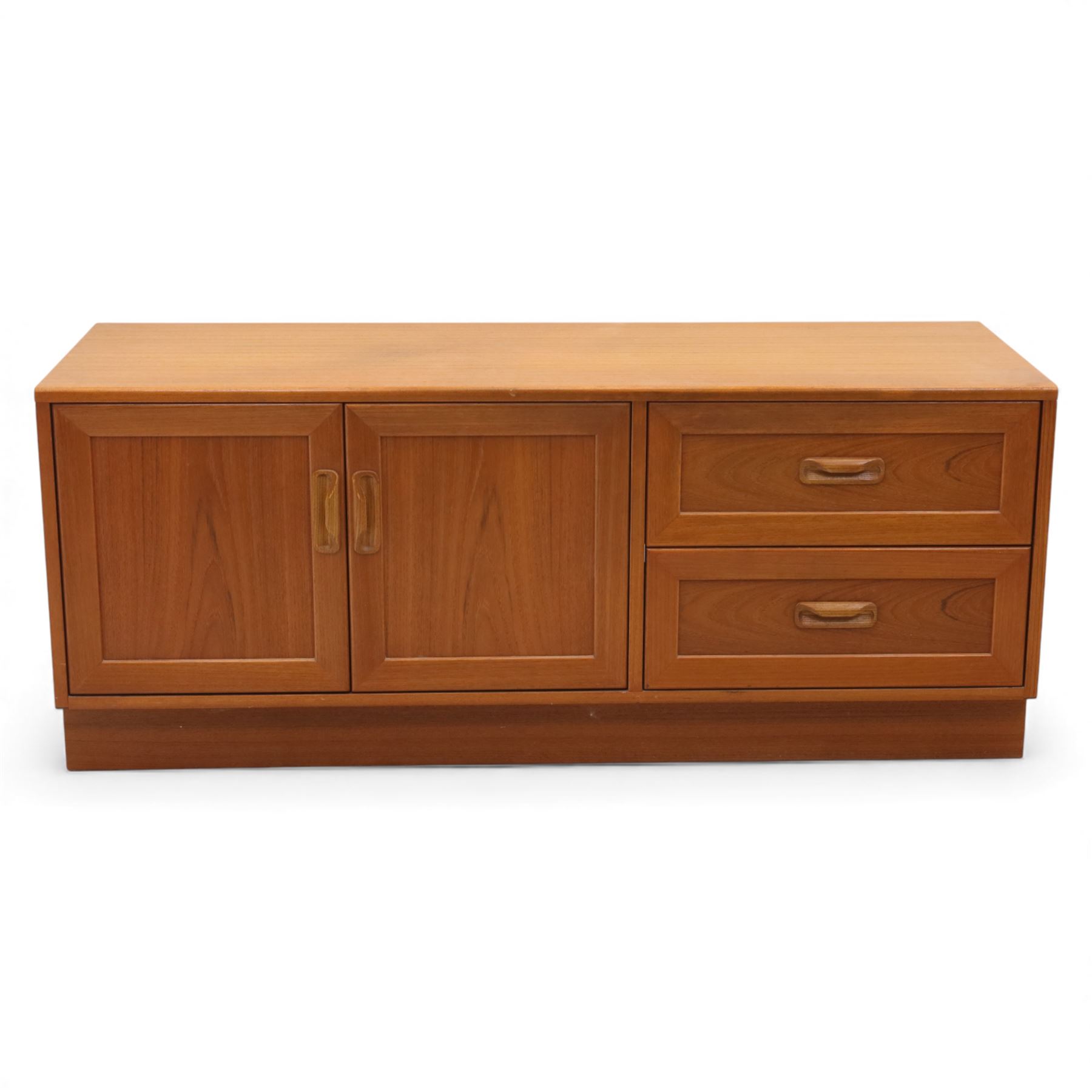 G Plan - 'Fresco' teak side unit, rectangular top above twin cupboard doors and two drawers, drawers fitted with cassette tape storage and a fall front drawer, raised on a plinth base